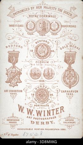Un'etichetta ornamentale per W.W. Winter, Art Photographer of Derby, che espone premi da mostre tra il 1884 e il 1886. Sono elencate medaglie di Cornovaglia, Bedford, Oldham, Dundee e Philadelphia. La carta enfatizza il trattamento artistico e il processo istantaneo, con il numero negativo 6787 stampato. Da un album fotografico del tardo vittoriano a quello del primo edoardiano, che presentava molte carte di albume e carte de visites, fornendo una finestra sugli stili e le mode dell'epoca. Foto Stock