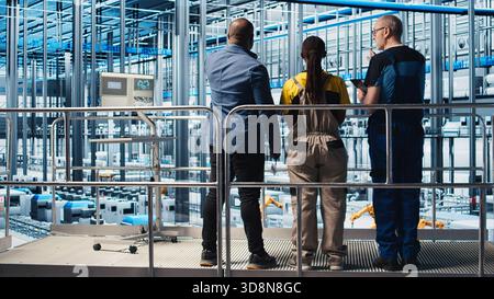 Responsabile dell'impianto fotovoltaico Industry 4,0 su piattaforma industriale che supervisiona il lavoro svolto dagli ingegneri per massimizzare la produzione di energia. Pannelli solari team leader di fabbrica intelligente che coordinano i lavoratori, fotocamera A. Foto Stock