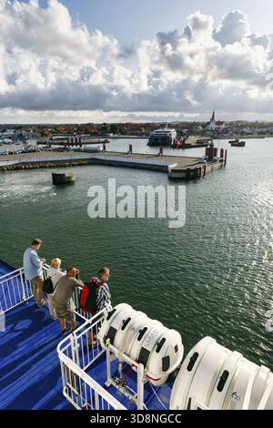 Turisti sul traghetto per Ruegen, terminal dei traghetti, porto con paesaggio urbano, Chiesa di San Nicola, cielo nuvoloso, Sunshine, Ronne, Roenne, Bornholm, Foto Stock