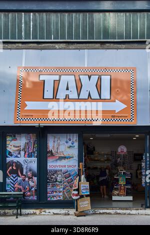 Dubrovnik. Croazia - 2 dicembre 2025: Un cartello arancione "TAXI" con un confine a scacchi e una freccia. Indica la direzione per i trasporti ufficiali Foto Stock