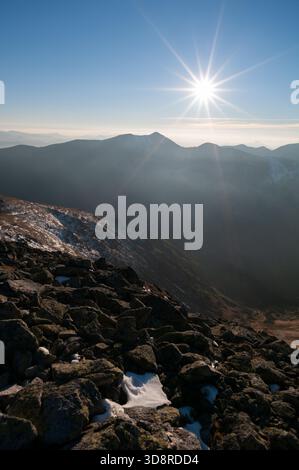 Vista aerea del sole che splende sulla catena montuosa con rocce in primo piano, Klin, regione di Zilina, Slovacchia. Foto Stock