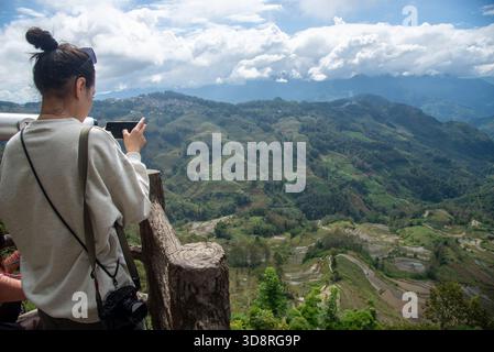 I turisti si trovano al punto di osservazione delle famose risaie terrazzate di Yuangyang nello Yunnan, in Cina Foto Stock