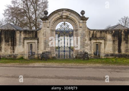 Porta ornata in ferro battuto con architettura storica in pietra ad Auberive, Francia Foto Stock