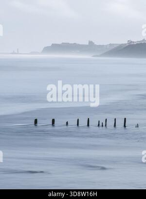 Immagine a lunga esposizione delle onde che si infrangono sulla spiaggia di Sands End, North Yorkshire, in una gustosa giornata d'inverno. Foto Stock