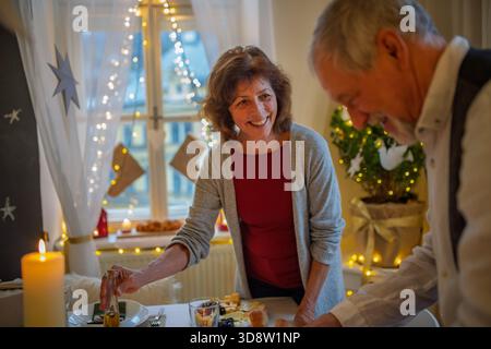La coppia più anziana prepara il tavolo per la cena di Natale. Foto Stock