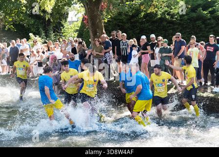 Ogni anno Bourton on Water a Cotswolds organizza una partita di calcio nel fiume Windrush attraverso la splendida città, un centro turistico, tutti bagnati Foto Stock