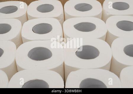 Rotoli di carta igienica impilati su una superficie in legno, concetto di igiene e pulizia domestica Foto Stock