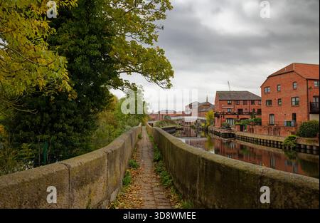 Un ponte pedonale in pietra sul fiume Trent che guarda verso gli appartamenti sul fiume vicino al canale di Newark on Trent, Nottinghamshire, Inghilterra. Foto Stock