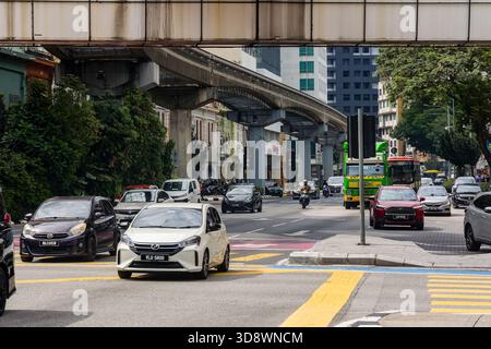 Vivace scena di strada con auto, moto e pista monorotaia a Kuala Lumpur Foto Stock