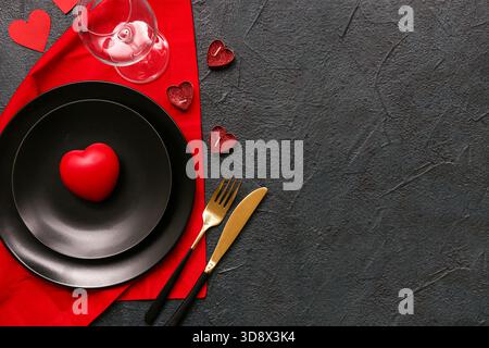 Tavolo per San Valentino con candele a forma di cuore e torta su sfondo scuro Foto Stock
