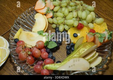 Piatto con fette di frutta variopinta, dessert, snack salutare, buffet vegeratico. Vista dall'alto. Foto Stock