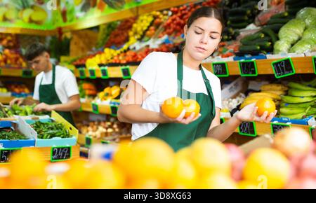 Ritratto di donna marketing che lavora presso il reparto frutta del negozio Foto Stock