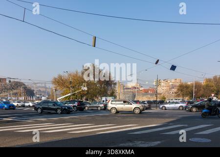 Erevan Armenia 10.25.2025. Un incrocio trafficato con auto e motociclette. La scena è caotica e movimentata. Le auto sono parcheggiate e in movimento, mentre il mese Foto Stock