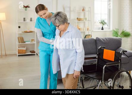 Aiutare la custode, l'infermiera gentile e premurosa, la donna anziana, aiutare gli anziani disabili a camminare Foto Stock