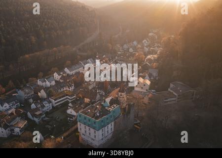 Foto panoramica di un villaggio di fronte a una fitta foresta sotto la luce soffusa del tramonto, Dillweisenstein, Pforzheim, Germania Foto Stock