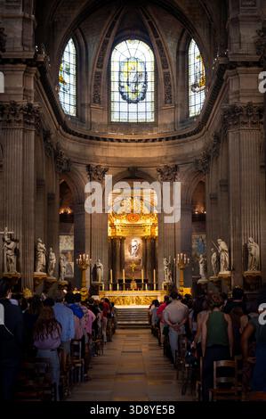 Parigi, Francia 08 04 2023: Una vista della navata centrale della cattedrale cattolica di Saint-Sulpice a Parigi, in Francia, con gente in piedi e in ascolto della pr Foto Stock