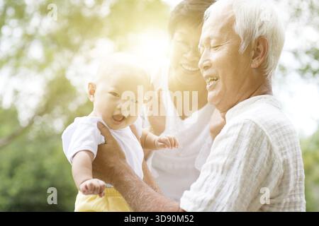 Nonni felici che giocano con il loro nipote nel parco all'aperto, famiglia asiatica, assicurazione sulla vita Foto Stock