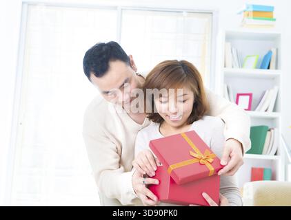 Uomo asiatico sorprese la sua fidanzata con un regalo Foto Stock