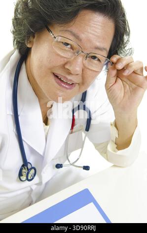 Asian senior medico donna regolando i suoi occhiali Foto Stock