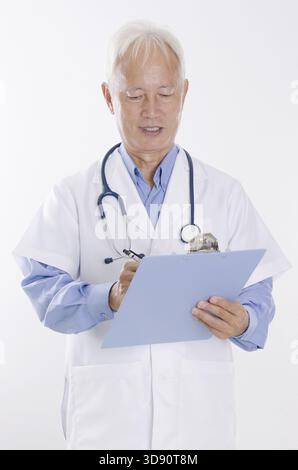 Ritratto del medico che scrive il rapporto sulla salute, in piedi isolato su sfondo bianco Foto Stock