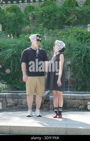 Un uomo e una donna sono in piedi l'uno accanto all'altro, entrambi con bandane bianche. Entrambi sorridono e sembrano godersi la reciproca compagnia Foto Stock