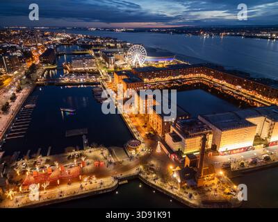 LIVERPOOL, MERSEYSIDE, INGHILTERRA - 21 NOVEMBRE 2025: Vista notturna dello storico Albert Dock e della moderna ruota panoramica sul lungomare di Liverpool, Foto Stock
