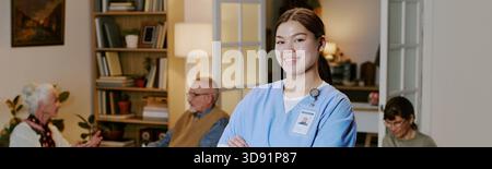 Ritratto di una giovane donna ispanica infermiera sorridente in una struttura di assistenza senior Foto Stock
