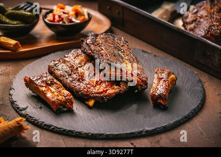 Deliziose costolette di ricambio con sottaceti sul tagliere Foto Stock