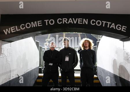 Londra, Regno Unito. 2 dicembre 2025. Il personale del Fulham posa per una foto all'interno dello stadio con un cartello Welcome to Craven Cottage prima della partita tra Fulham e Manchester City Premier League al Craven Cottage, Londra, Inghilterra, il 2 dicembre 2025 credito: Sally Rawlins/Every Second Media Credit: Every Second Media/Alamy Live News Foto Stock