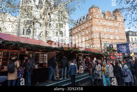 Londra, Regno Unito, 23 novembre 2025: Persone che navigano e fanno shopping al mercatino natalizio in una piazza leicester a Londra Foto Stock