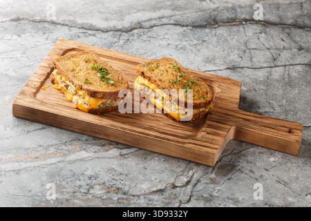Deliziosi crostini di tonno fresco a base di pane di segale, tonno in scatola con verdure e maionese e formaggio fuso da vicino su un tavolo di legno sulla t Foto Stock