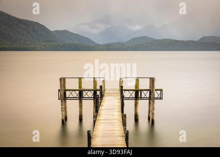 Molo di legno sul lago te Anau, Isola del Sud, nuova Zelanda. Autunno (maggio) 2025. Foto Stock