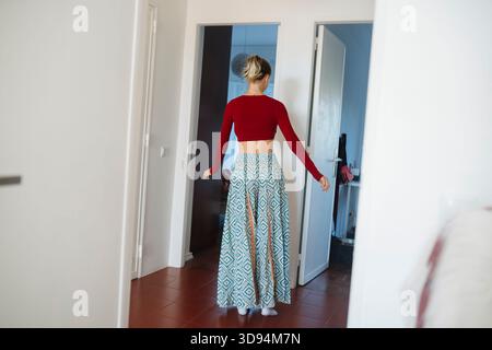 Redclad Woman attraversa il corridoio con un ambiente rilassato Foto Stock
