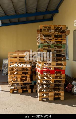 Le pile di pallet in legno sono immagazzinate in un deposito industriale, pronto per la spedizione, il trasporto, la logistica, lo stoccaggio, e l'uso della catena di fornitura. Foto Stock