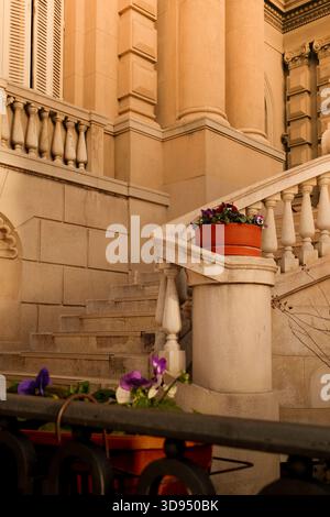 Eleganti scale in pietra e dettagli architettonici classici illuminati dalla calda luce del sole Foto Stock