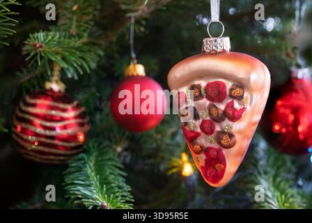 Un ornamento di un bicchiere di pizza appeso su un albero di Natale. Foto Stock