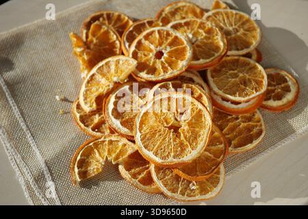 Fette di arancia essiccate su una superficie di tessuto alla luce del sole Foto Stock