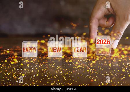 Banner Concept per il felice anno nuovo 2026. Gira il calendario con i numeri da 2025 a 2026 su cubi di legno, isolati su uno sfondo bokeh. Foto Stock