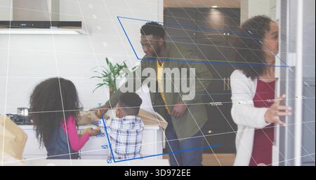 Disimballaggio della famiglia collocando generi alimentari e sacchetti di carta sul piano di lavoro della cucina, uomo in giacca di oliva Foto Stock