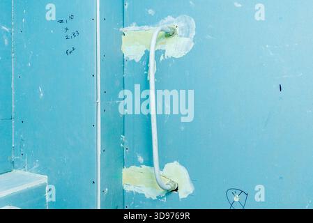 Ci stiamo preparando a installare una nuova parete in cartongesso e un sistema di riscaldamento ad acqua calda nel bagno della casa in fase di ristrutturazione. Foto Stock