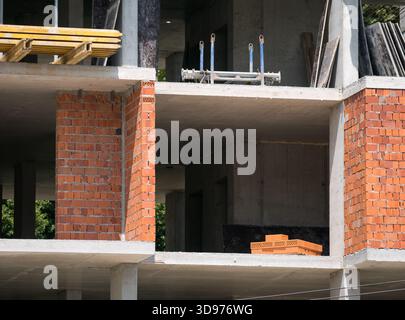 Primo piano dettagliato di una sezione di un edificio monolitico in costruzione, caratterizzato da pareti in mattoni ed elementi strutturali Foto Stock