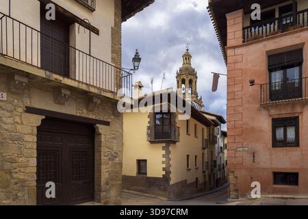 I sentieri tortuosi di Rubielos de Mora mostrano un'architettura affascinante e un alto campanile sotto un cielo spettacolare, invitante esplorazione, Teruel, Spagna Foto Stock