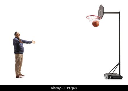 Uomo felice che segna un punto con un pallacanestro isolato su sfondo bianco Foto Stock