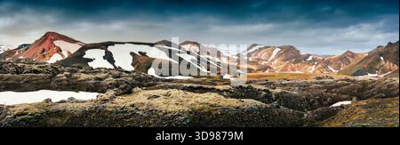 Paesaggio panoramico della montagna riolite vulcanica di Landmannalaugar con innevata, roccia lavica nera con muschio ricoperto in estate nelle Highlands islandesi Foto Stock