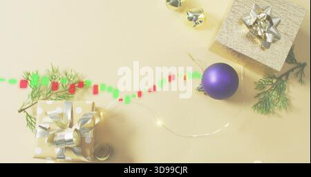 Mostra un regalo a pois oro con fiocco in metallo su un tavolo beige pallido, luci da favola, percorso digitale Foto Stock