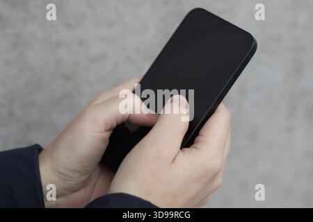 Mani femminili con uno smartphone nero Foto Stock