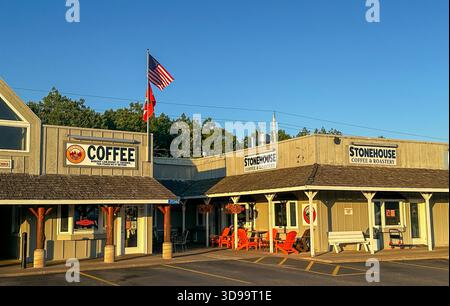 NISSWA, MN - 01 luglio 2025: Una popolare caffetteria nel Minnesota centrale è vista alla luce della sera con una bandiera americana che sventola in alto. Foto Stock