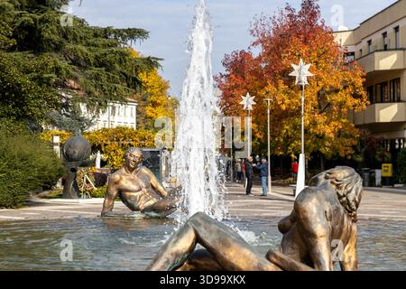 Abano Terme, Italia - 29 ottobre 2025: Fontana centrale sculture con alberi autunnali nel centro del paese Foto Stock