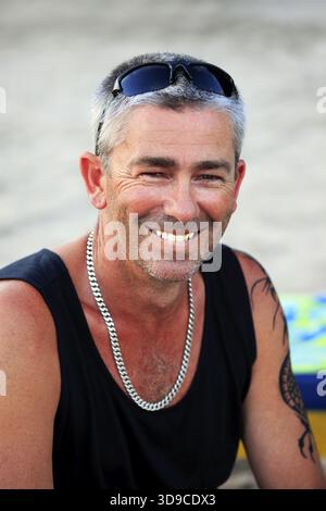 Ritratto di un uomo adulto sorridente verso la fotocamera. Scatto verticale Foto Stock