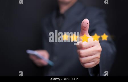 Un uomo d'affari che dà un pollice con un volto sorridente e cinque stelle brillanti, simboleggiando la soddisfazione del cliente, l'esperienza positiva, il servizio qu Foto Stock